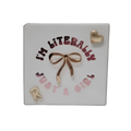 White personalized gift pouch featuring the text “I’M HEBREWISH” with a decorative brown bow, gold heart accent, and colorful Hebrew-themed lettering and symbols.