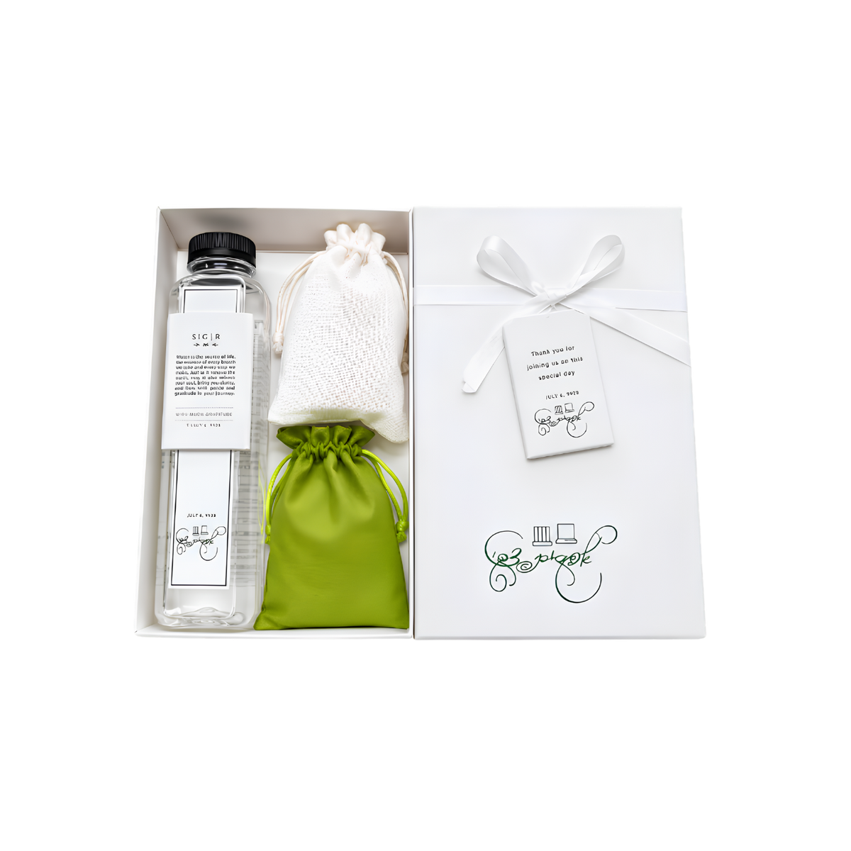 Personalized white gift set arranged in an open box, featuring a glass bottle, small fabric pouches, a green drawstring bag, and a white gift package with ribbon and tags.