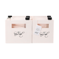 Two pink gift bags with handles, each featuring a small decorative floral design and a rectangular name tag holder on the front.