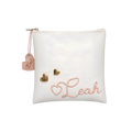 White personalized square cushion featuring elegant pink embroidered lettering reading “Leah,” with small gold heart accents and a decorative hanging tag.