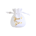 White personalized drawstring gift pouch with gold script lettering reading “Yossi & Yides,” finished with white cord ties and a small decorative gold accent.