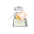 White mesh gift pouch tied with a white ribbon, containing small white favors and decorated with a pink floral gift tag.